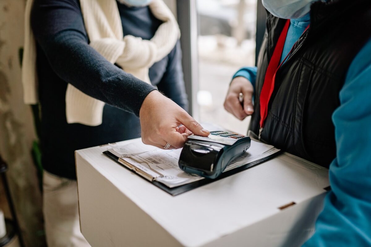 A person tapping a credit card on the POS system